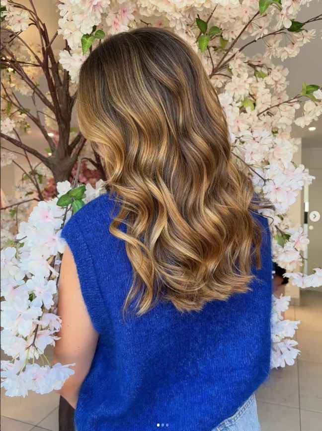 Balayage caramel sur cheveux longs ondulés réalisé à Honfleur