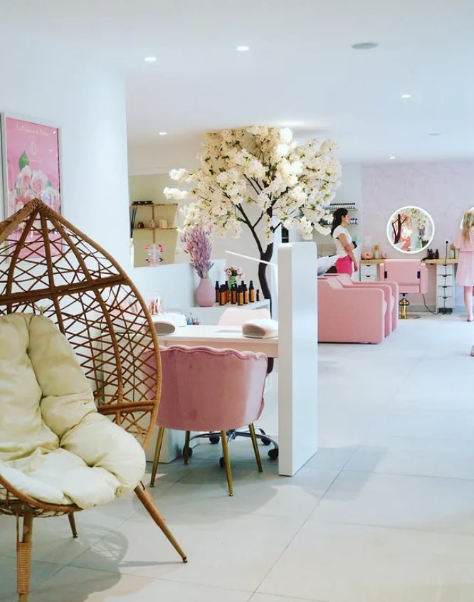 Salle principale du salon Lola Coiffure & Beauté à Honfleur, fauteuil en rotin et cerisier en fleurs